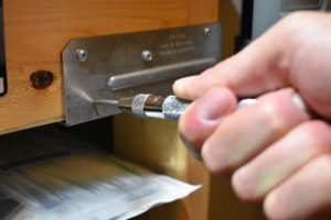 Using a drill punch on a piece of aluminum