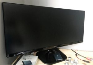 widescreen monitor resting on a work bench