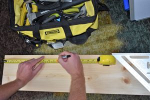 measuring a piece of 2x6 with a tape measure